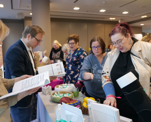 Ein Event mit vielen Menschen, einige von ihnen halten ein Heft in der Hand und lesen es