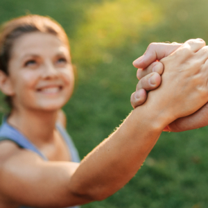 junge Frau beim Sport erhält Hilfe beim Aufstehen